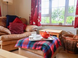 A living room with a sofa and a tea set at Barn Close Farm in Morcombelake