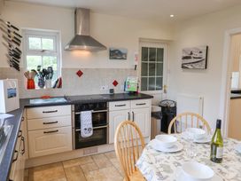 A kitchen with utensils and a dining table at Barn Close Farm in Morcombelake