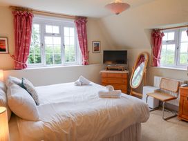 A bedroom with a bed and television at Barn Close Farm Morcombelake
