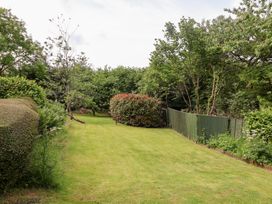 A garden with grass, trees, hedges, and a fence at Barn Close Farm Morcombelake