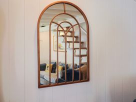 A mirror reflecting a staircase and a couch at Cleve Cottage in Lyme Regis