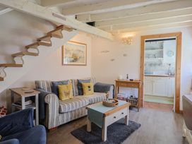 A living room with a sofa and stairs at Cleve Cottage Lyme Regis