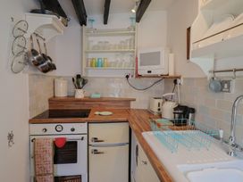 A kitchen with a cooktop, oven, and refrigerator at Cleve Cottage, Lyme Regis