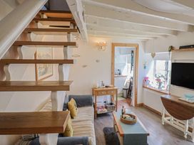 A living room with a staircase and sofa at Cleve Cottage in Lyme Regis
