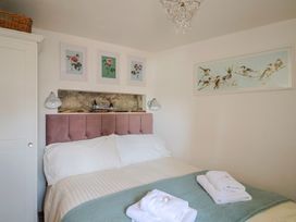 A bedroom with a bed and wall art at Cleve Cottage in Lyme Regis