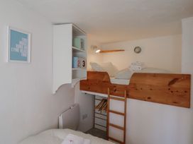 A bedroom with a loft bed and shelf units at Cleve Cottage in Lyme Regis