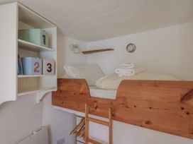 A bedroom with a loft bed and shelves at Cleve Cottage in Lyme Regis