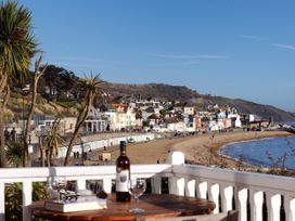 A beach view with houses and palm trees at 1 Wellhayes Lyme Regis
