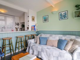A living room with a sofa and bar stools at 1 Wellhayes Lyme Regis