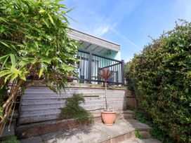 A garden area with a wooden deck and plants at 1 Wellhayes Lyme Regis