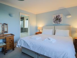 A bedroom with a bed and a dresser at High Cliff Orchard in Lyme Regis