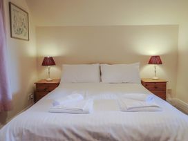 A bedroom with a bed, nightstands, and lamps at High Cliff Orchard in Lyme Regis