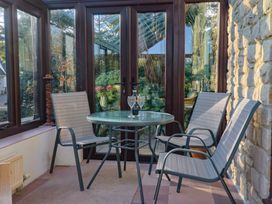 A conservatory with a table and chairs at High Cliff Orchard in Lyme Regis