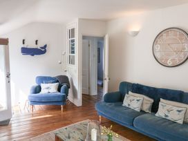 A living room with a blue sofa and armchair at The Bakehouse in Lyme Regis