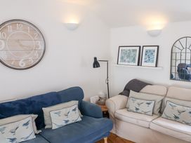 A living room with a clock and sofas at The Bakehouse in Lyme Regis