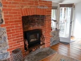 A living room with a fireplace and door to the outdoor area at The Bakehouse in Lyme Regis