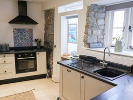 A kitchen with a sink, oven, and window at The Bakehouse in Lyme Regis