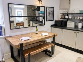 A kitchen with a wooden table and wine bottle at The Bakehouse in Lyme Regis