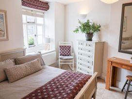 A bedroom with a bed and chair at The Bakehouse in Lyme Regis