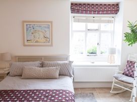 A bedroom with a bed, lamp, and window at The Bakehouse in Lyme Regis