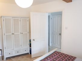 A bedroom with a wardrobe and doors at The Bakehouse in Lyme Regis