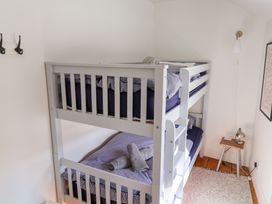 A bedroom with a bunk bed and a table lamp at The Bakehouse in Lyme Regis