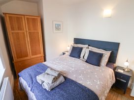 A bedroom with a bed and wardrobe at The Bakehouse in Lyme Regis