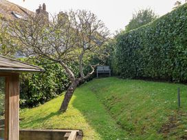 A garden with a bench and tree at The Bakehouse in Lyme Regis