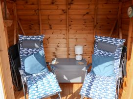 A garden shed with two deck chairs and a side table at The Bakehouse in Lyme Regis