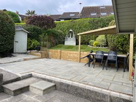 A garden with a patio, table, chairs, and a shed at The Bakehouse in Lyme Regis