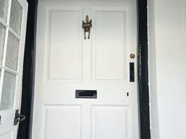 A front door with a knocker and mail slot at Foxley Cottage in Charmouth