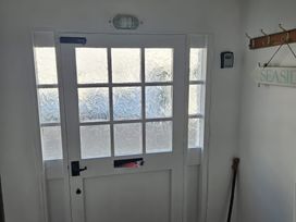 A hallway with a door and a sign at Foxley Cottage in Charmouth