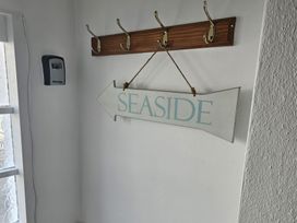An entryway with coat hooks and a seaside sign at Foxley Cottage in Charmouth