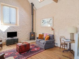 A living room with a sofa and television at The Stone Barn in Bridport