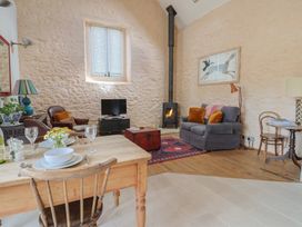 A living room with a dining table and sofa at The Stone Barn in Bridport
