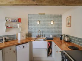 A kitchen with sink, appliances and storage at The Stone Barn in Bridport
