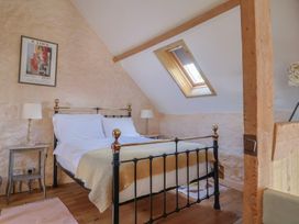 A bedroom with a bed and nightstand at The Stone Barn in Bridport