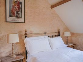 A bedroom with a bed and lamps at The Stone Barn in Bridport