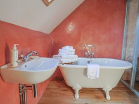 A bathroom with a bathtub and washbasin at The Stone Barn in Bridport