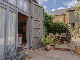 An outdoor seating area with a table and chairs at The Stone Barn in Bridport