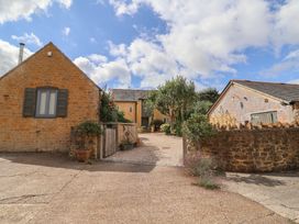 An outdoor view of buildings and trees at The Stone Barn in Bridport