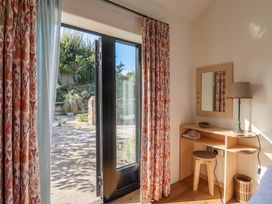 A bedroom with a desk and window open to outdoor at The Dairy in Bridport