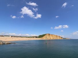 View of a beach with cliffs and water at The Dairy in Bridport