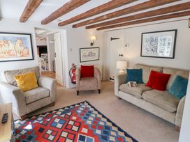 A living room with sofas armchair colorful cushions patterned rug and framed artwork at The Gatehouse in Axmouth