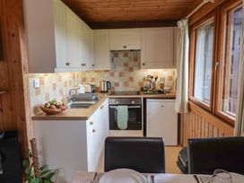 A kitchen with appliances and dining setup at 10 Pinewood Retreat in Pinewood