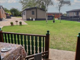 A garden with grass and cabins at 10 Pinewood Retreat in Pinewood