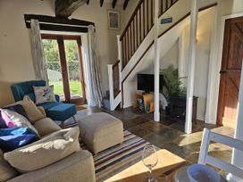A living room with a sofa and TV at The Cider House in Dalwood