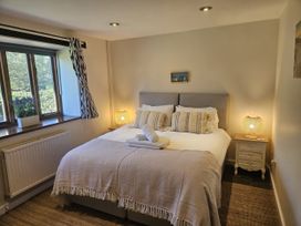 A bedroom with a double bed and two lamps at The Cider House in Dalwood