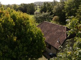 A house with a roof and trees in the garden at The Cider House in Dalwood