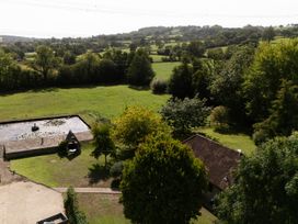 A garden with a pond and trees at The Cider House in Dalwood